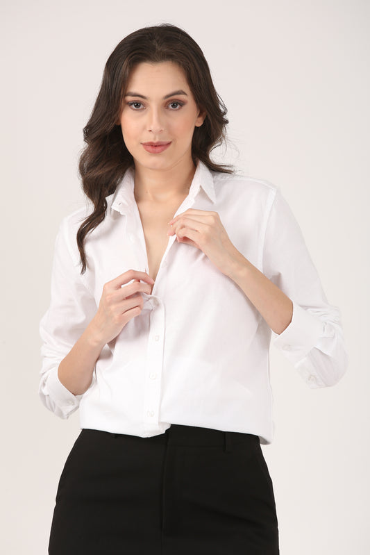 Woman wearing a classic white Oxford cotton shirt with full sleeves and black trousers, front buttoned and collar open