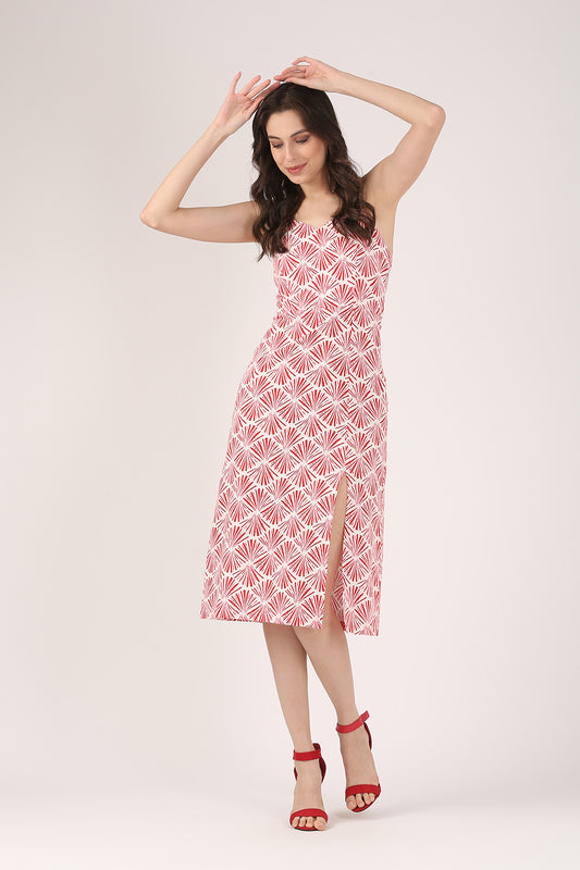Woman wearing a sleeveless red and white printed cotton midi dress with thin straps and a high side slit