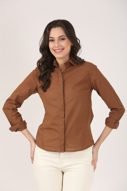 Woman wearing a brown full-sleeve cotton poplin shirt with a concealed button placket and rolled-up sleeves